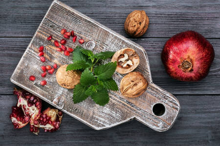 Pomegranate and walnut on a board
