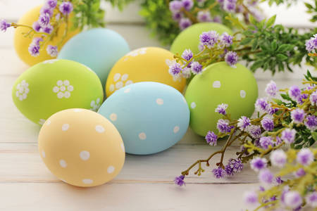 Huevos de Pascua en una mesa con flores