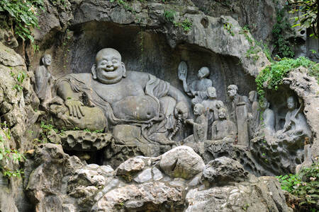 Statue de Bouddha rieur dans le rocher