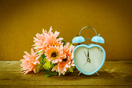 Alarm clock and bouquet of flowers