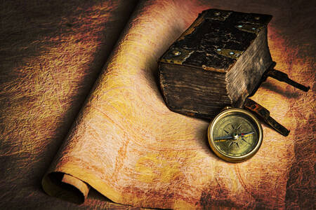 Kompass und Buch auf dem Tisch