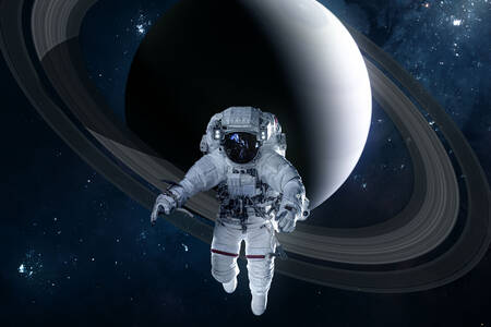 An astronaut with Saturn in the background