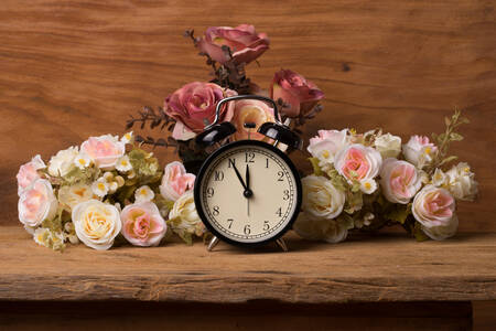 Alarm clock with flowers on the table