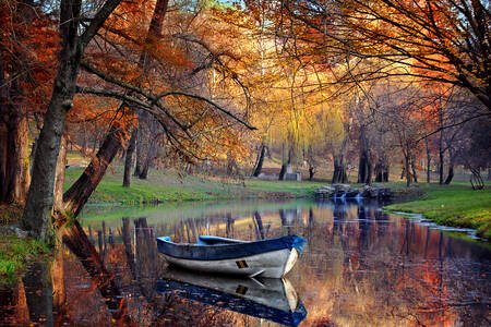Barco em um lago na floresta de outono