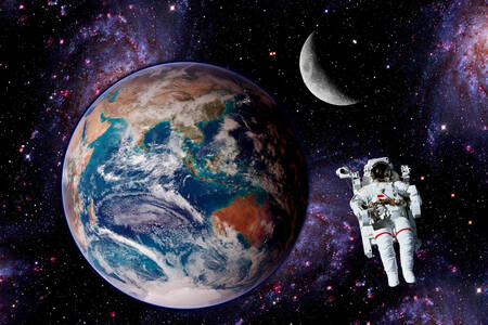 Un astronauta con la Tierra y la Luna de fondo