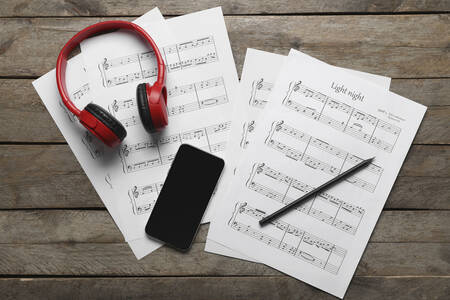 Phone, headphones and music sheets