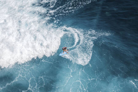Seorang peselancar yang sedang menunggangi ombak laut