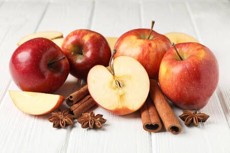 Яблука і кориця на дерев’яному тлі