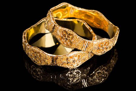 Guldbelagte armbånd på sort baggrund