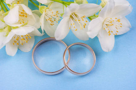 Alianças de casamento e flores brancas