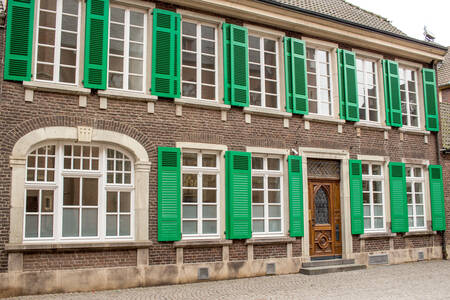 Фасад старого дома с зеленым ставнями