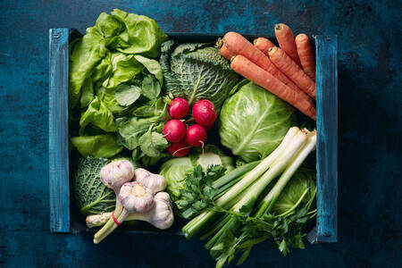 Verduras en una caja sobre la mesa.