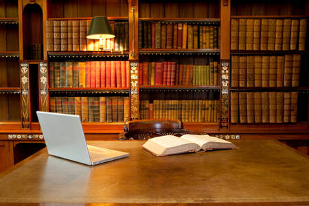 Ordinateur portable et livre à la bibliothèque