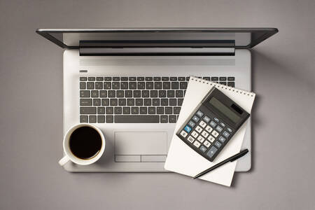 Сірий ноутбук, блокнот та калькулятор