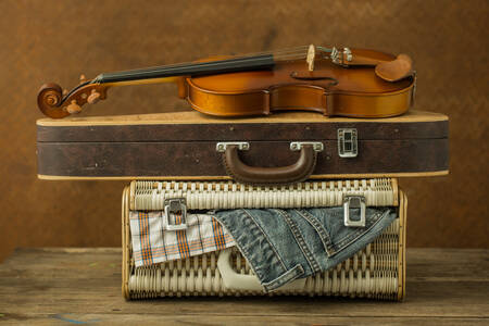 Un vieux violon et un étui sur une valise