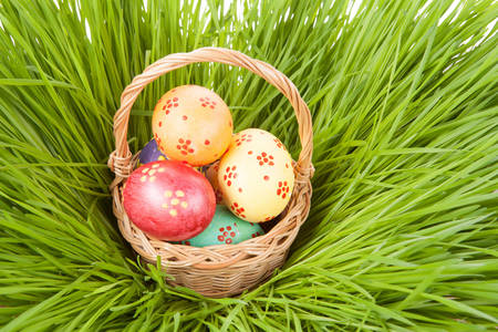 Basket with Easter eggs in the grass