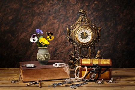 Masanın üzerinde antika saat ve süslemeler