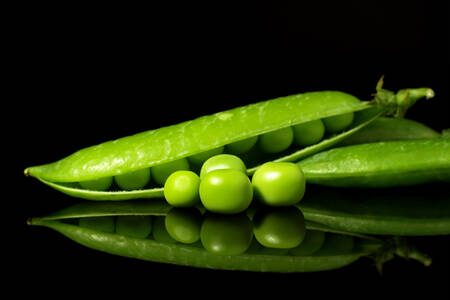 Green peas on a black background