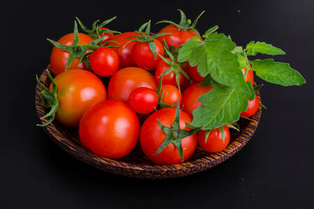 Ripe tomatoes on a black background