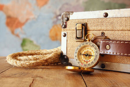 Suitcase and compass on the table