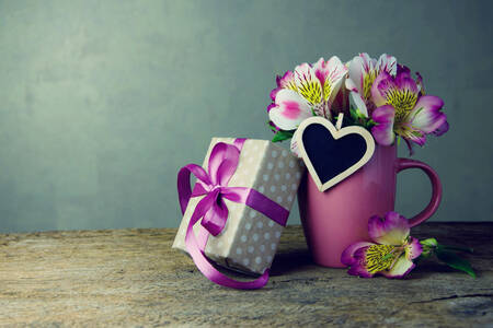 Blumen in einer Tasse und ein Geschenk