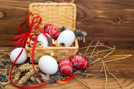 Великденски яйца в кошница на масата