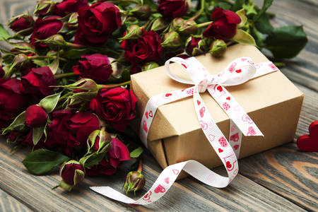 Bouquet of roses and a gift on the table