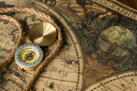 An old brass compass on a map