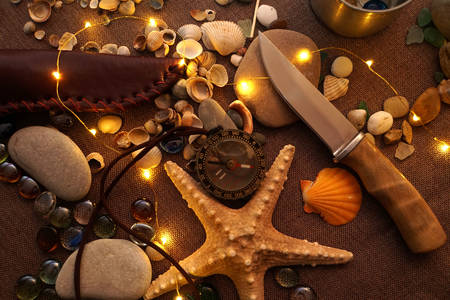 Нож на фоне из морских сувениров