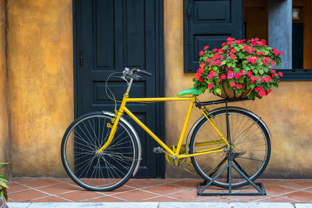 Vélo jaune avec un panier de fleurs