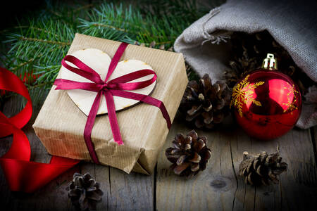 Gift, fir branches, and pinecones on the table