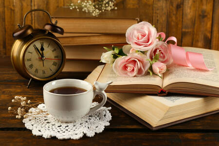 Zegar, filiżanka herbaty i kwiaty
