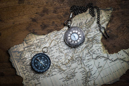 Brújula y reloj de bolsillo en el mapa