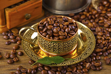 Una taza dorada con granos de café