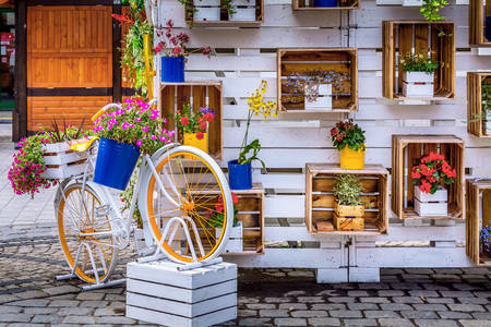 Велосипед и деревянная стойка с цветами