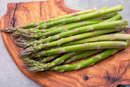 Asperges vertes sur une planche en bois