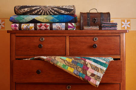 Des couvertures sur une vieille commode