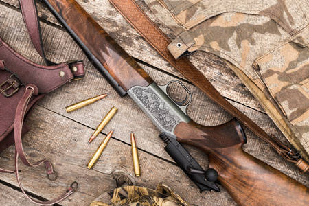 Rifle de caça e cartuchos na mesa