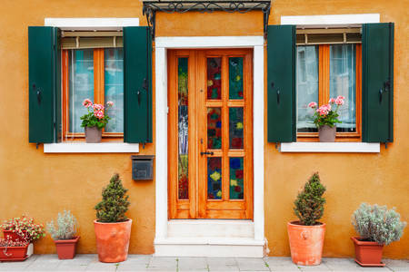Facade of a yellow house with flowers